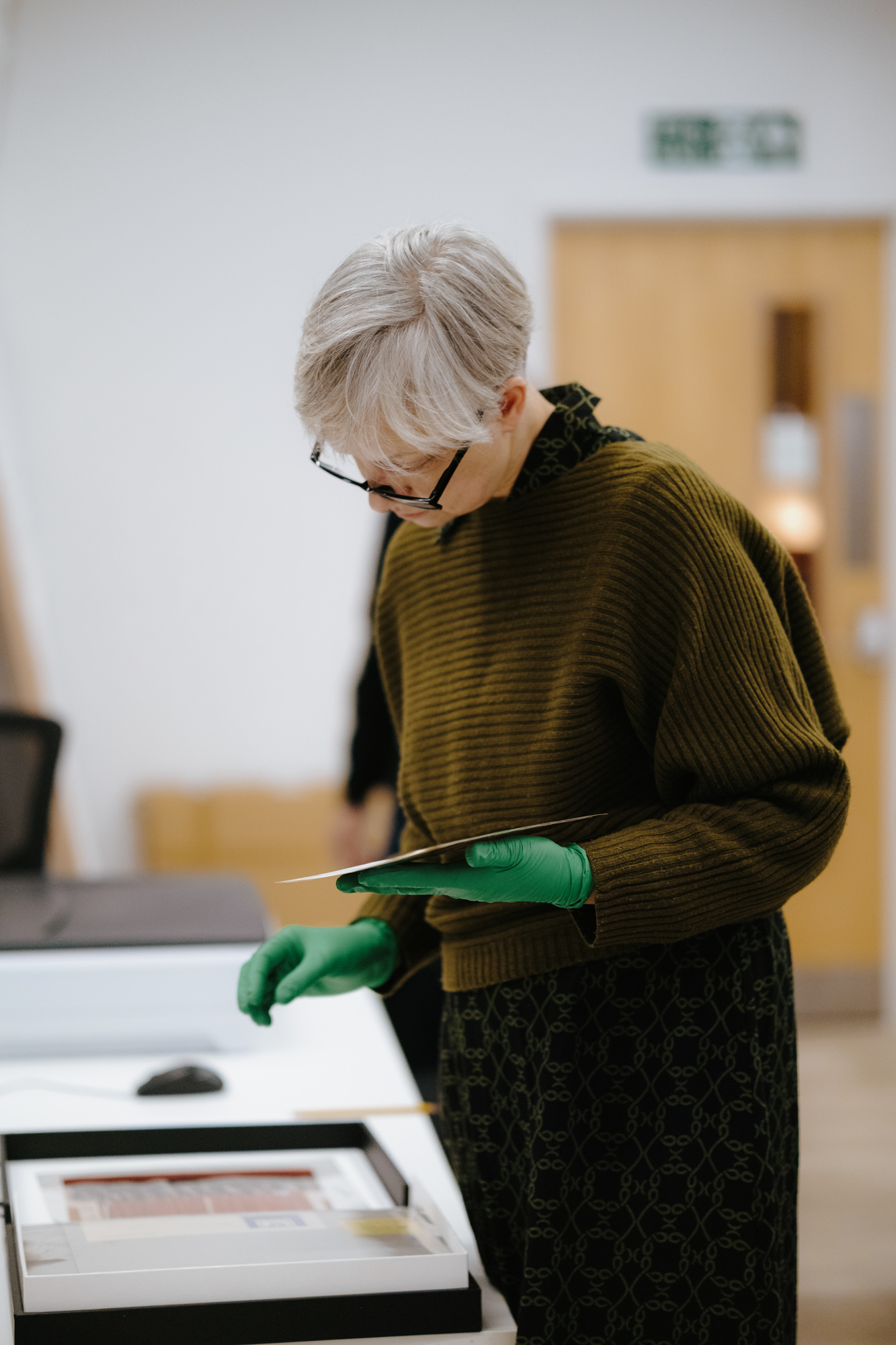 TheAmelia-Digitisation-8 Lady wearing gloves handling exhibits
