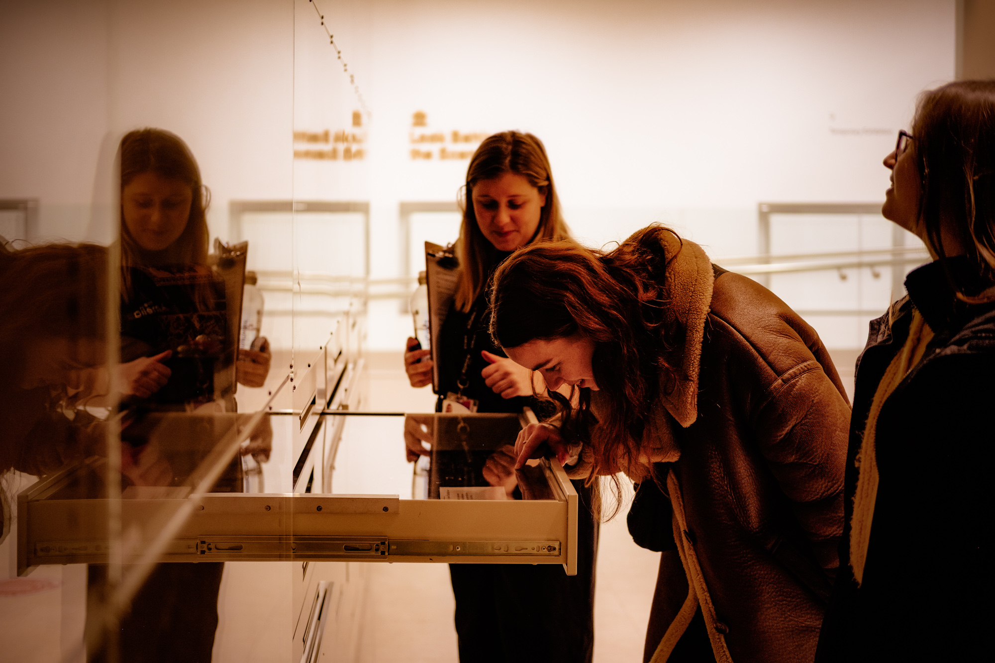 TheAmelia-General-65 3 females looking at exhibits in a drawer