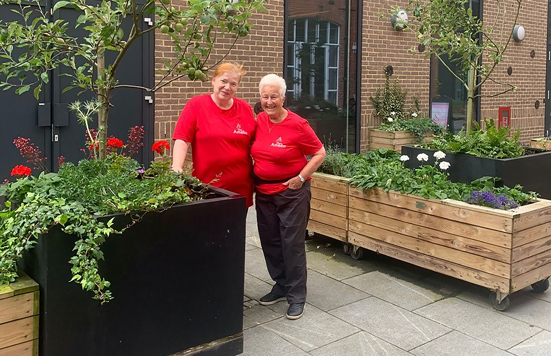 volunteers-v2 2 lady volunteers at the Amelia Scott in red t-shirts
