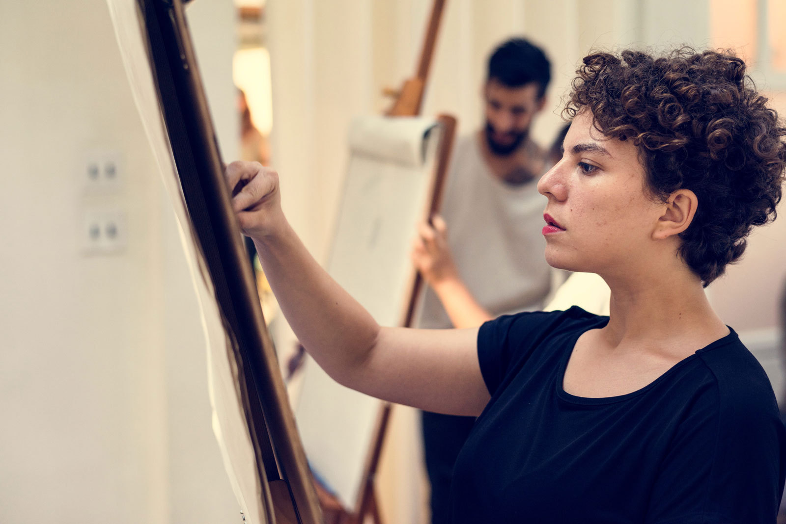 female doing art on an easel