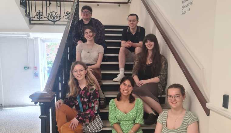 The Young producers seated on the steps of the Amelia building