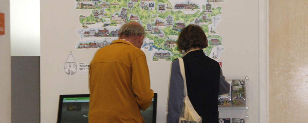 Two visitors looking through the tourist information leaflets