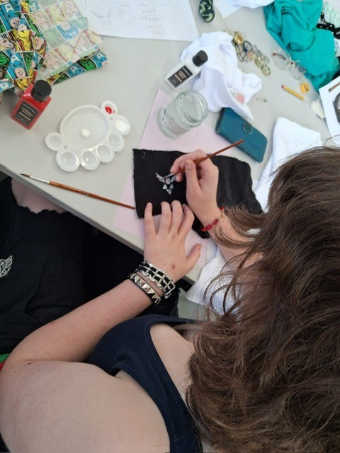 4 girl drawing a design on black card