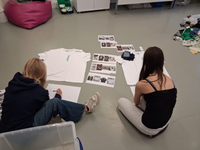 two girls on floor designing t shirts